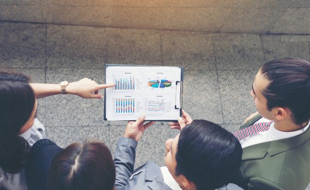 Business teamwork with document in her hands, watching some inte Business teamwork with document in her hands, watching some interesting content during lunch break